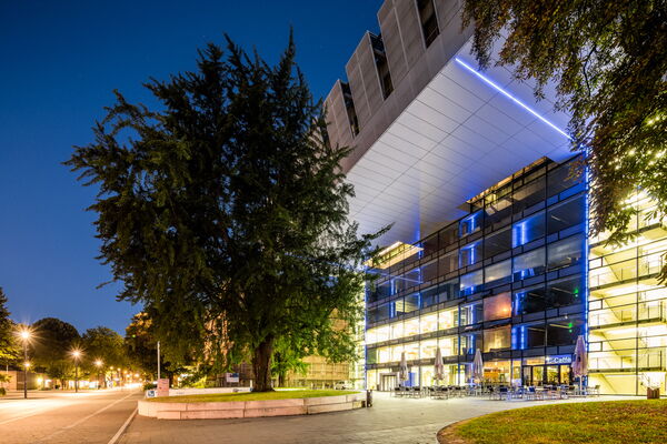 A central building of RWTH Aachen with large tree in from of it is shown.