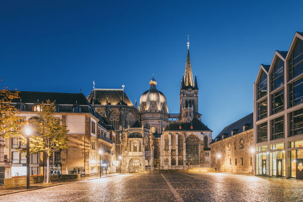 A view of Aachner Dom from a distance in twilight.