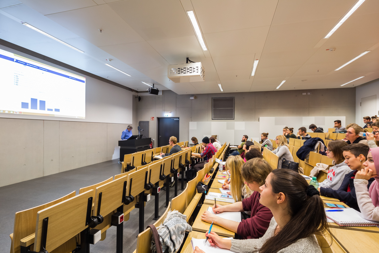 The students listen to lecture in a lecture hall.