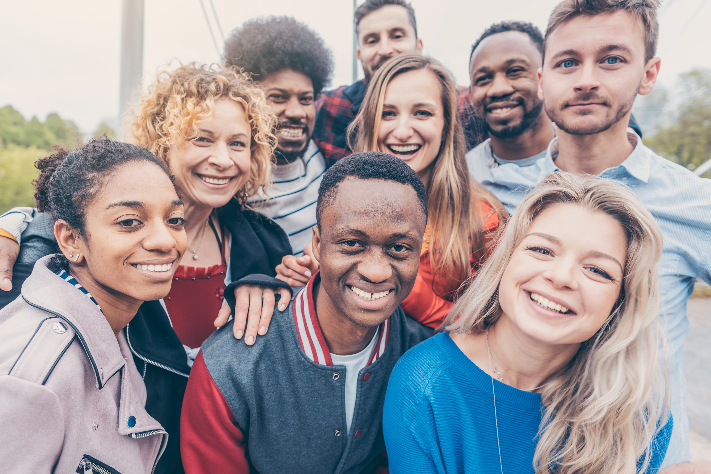 Students from different countries stand together, smile and give a friendly pose.